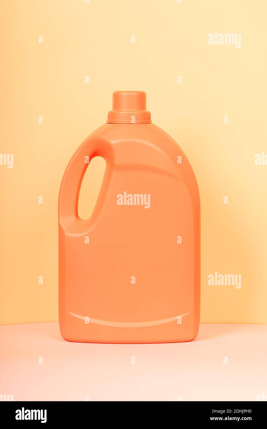 Bright plastic container from liquid detergent placed on vivid yellow background in studio Stock Photo