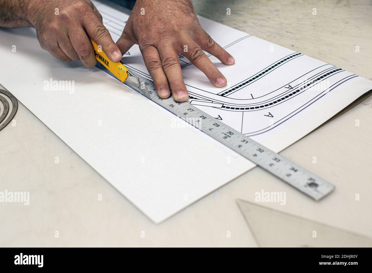 Close up of man cutting a blueprint Stock Photo