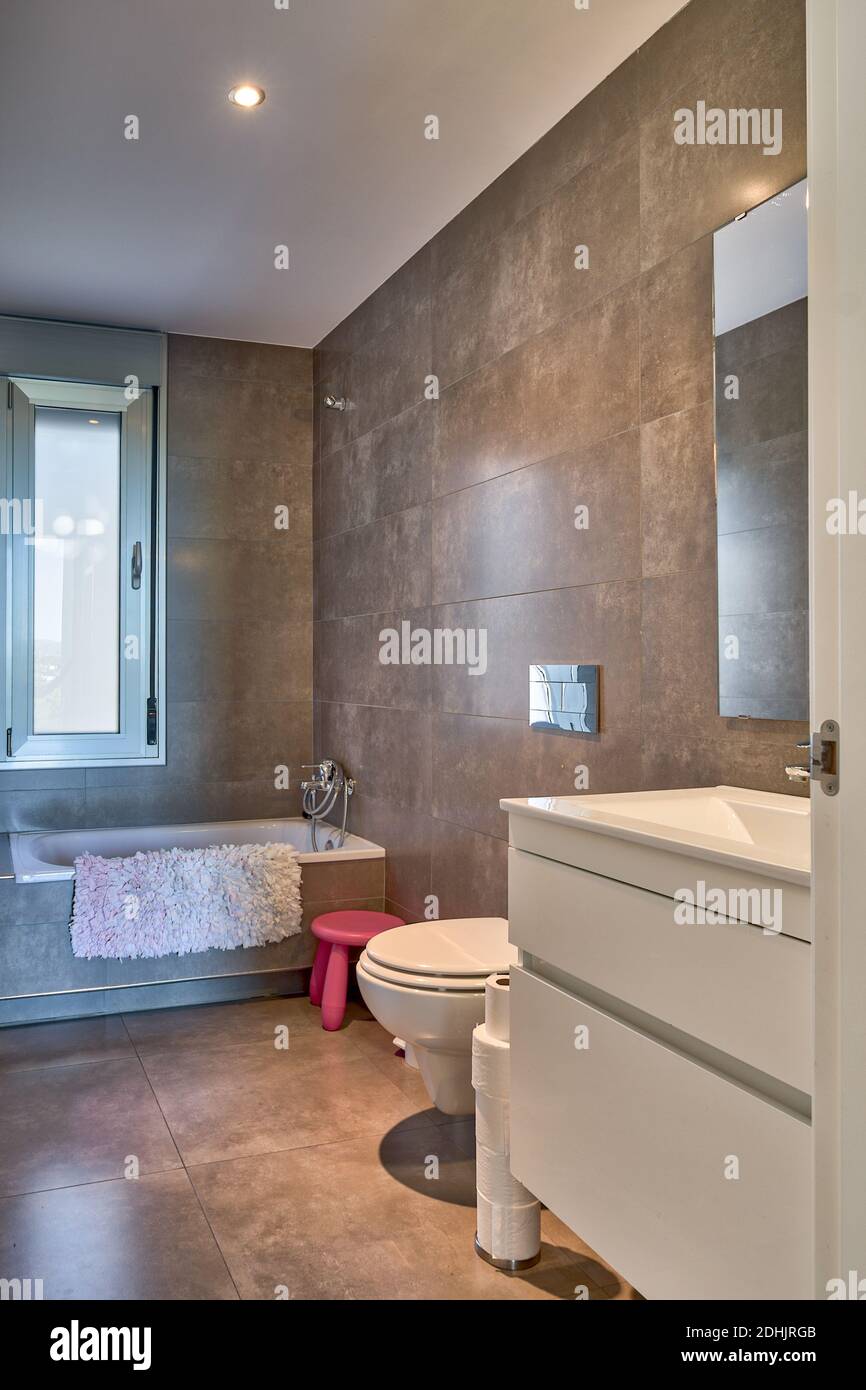 Interior of bathroom in white and beige colors with bathtub and toilet ...