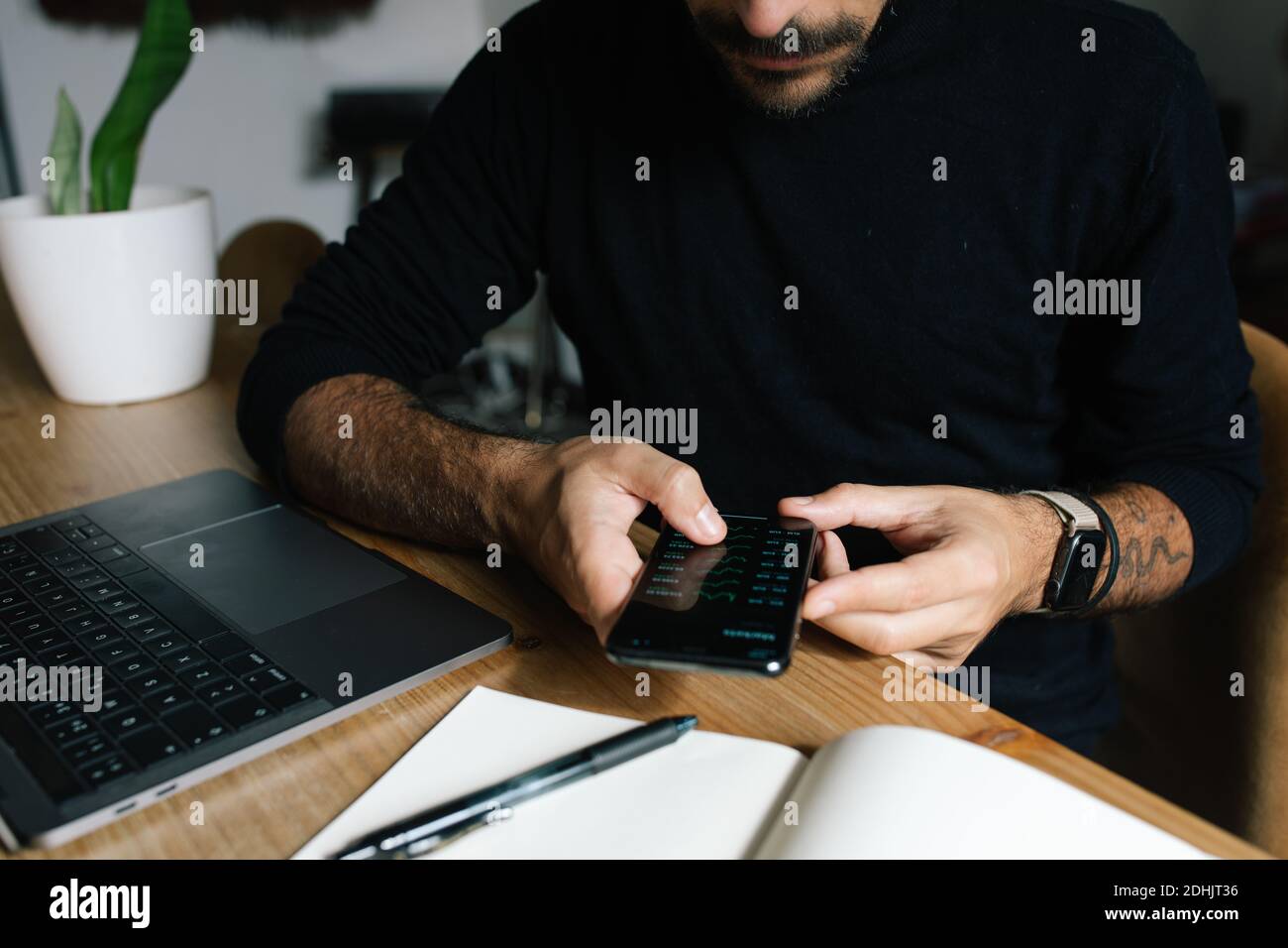 Crop anonymous male entrepreneur using mobile app and working with ...