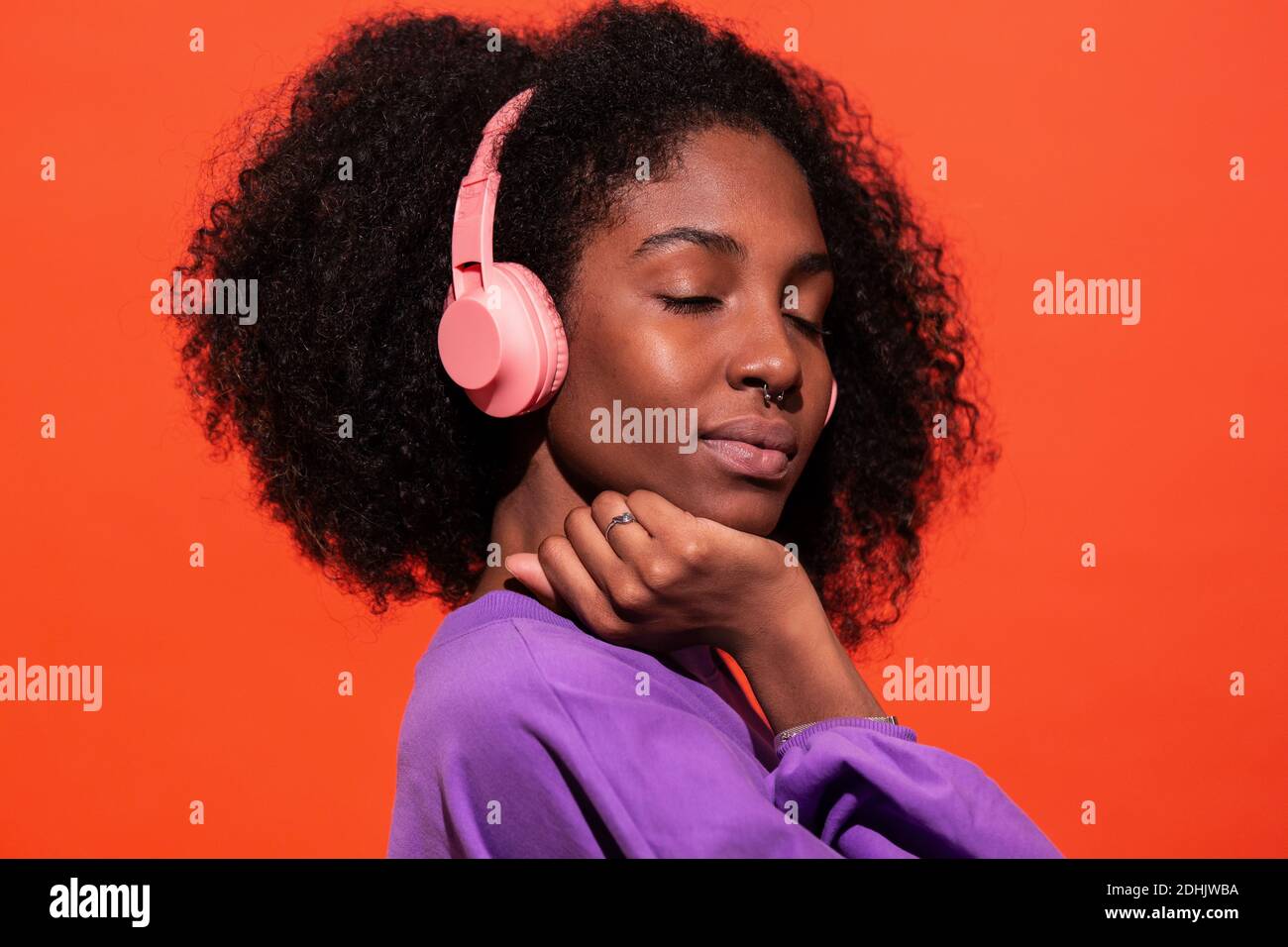 Modern unemotional black Woman with Afro hairstyle wearing pink