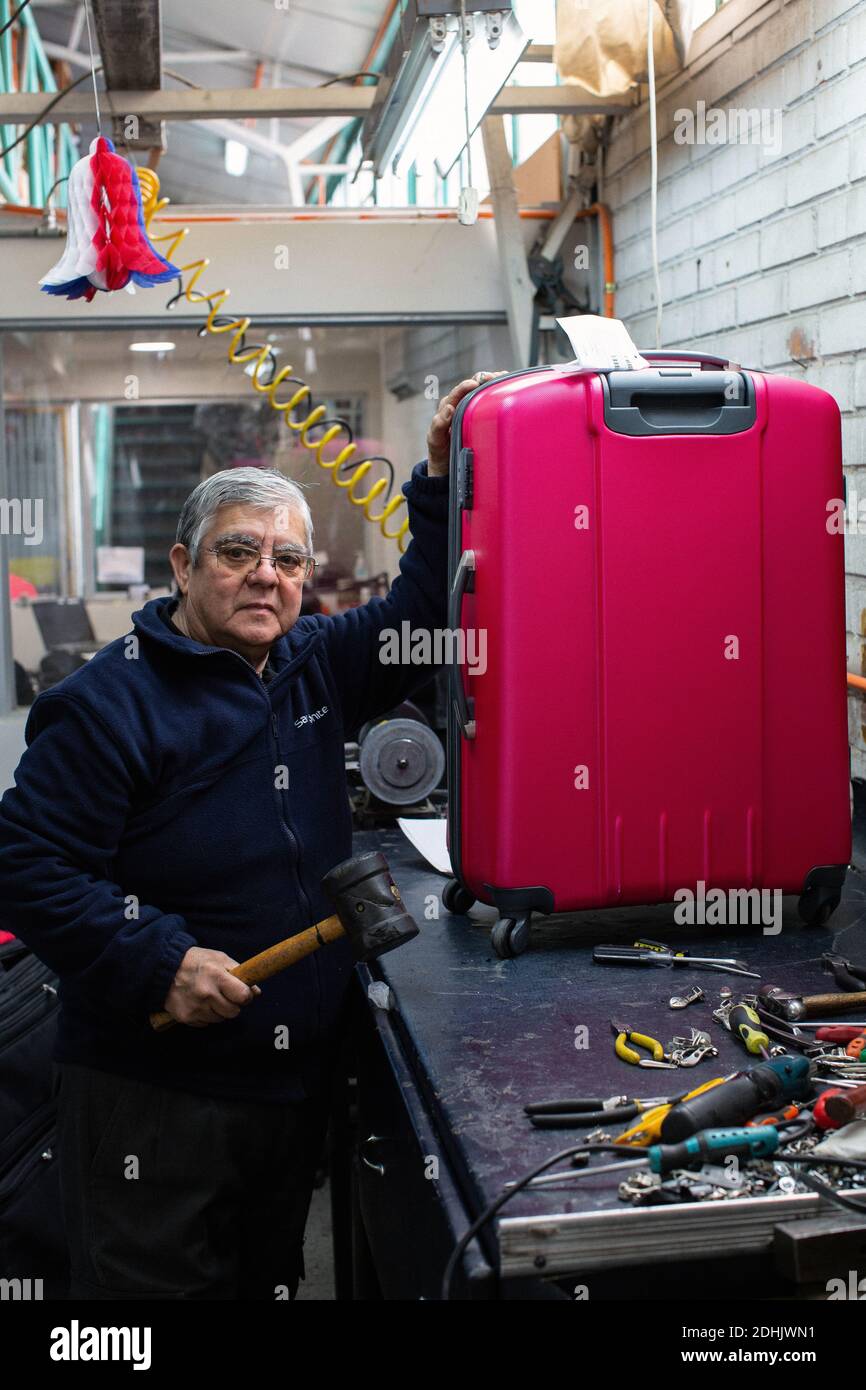 Male worker is repairing luggage with with hammer at workshop in Santiago , Chile Stock Photo