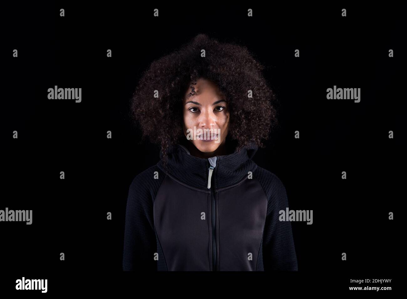 Young African American female with curly hair wearing black clothes ...
