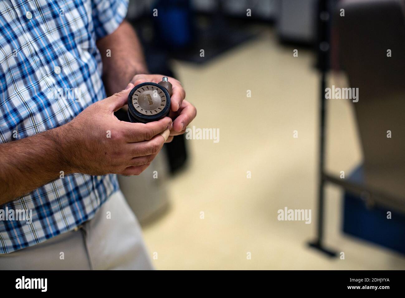 Quality Assurance Manager is holding a wheel for suitcase at Samsonite quality lab in Mansfield, Massachusetts,United States Stock Photo