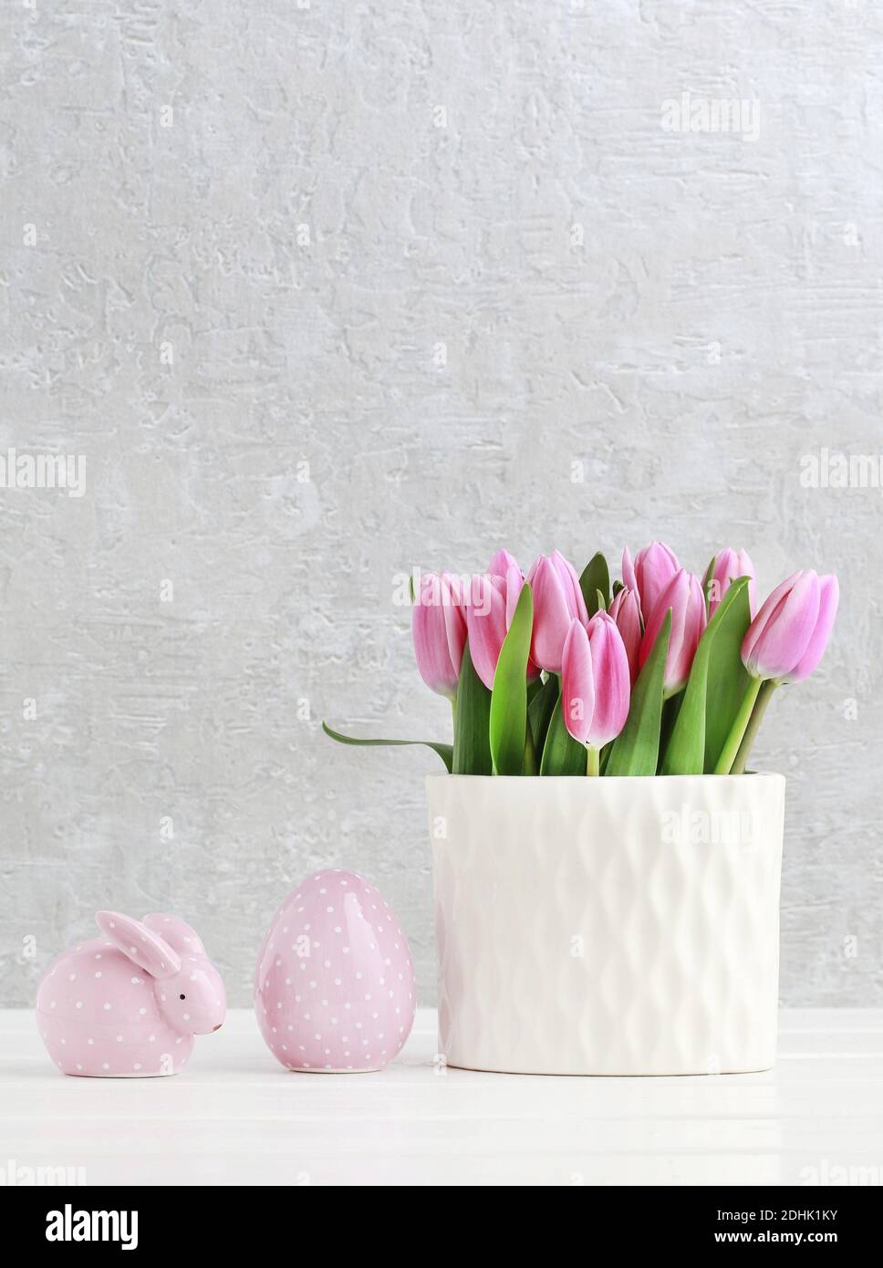Beautiful pink tulips in ceramic vase, dotted rabbit and Easter egg ...