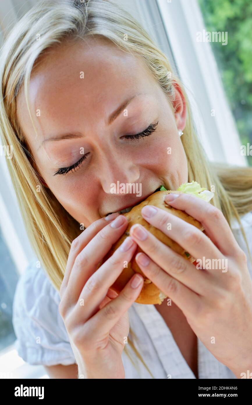 Woman eating a sandwich Stock Photo
