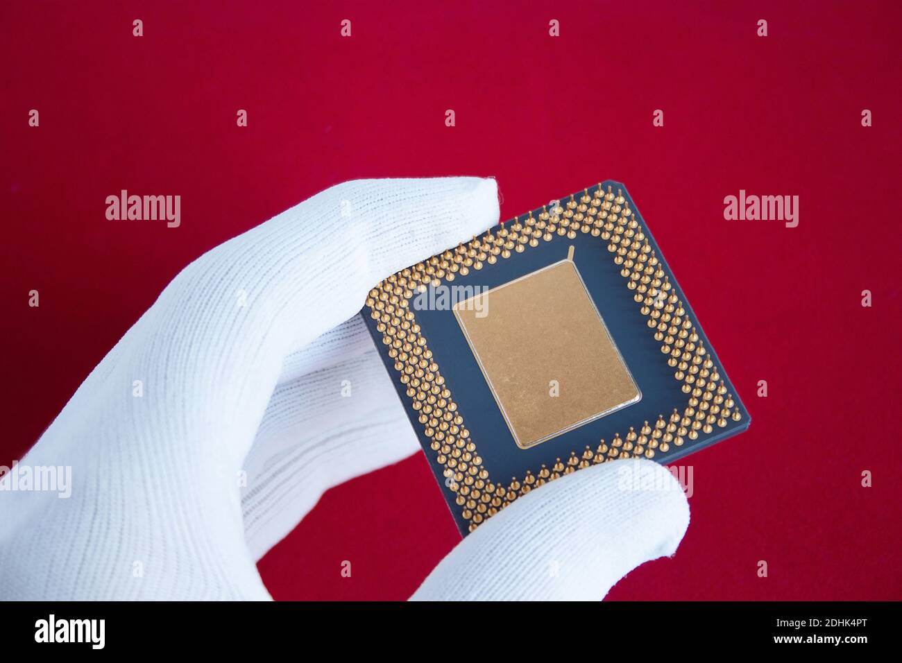 Hand in white glove holds a computer chip. Closeup. Stock Photo