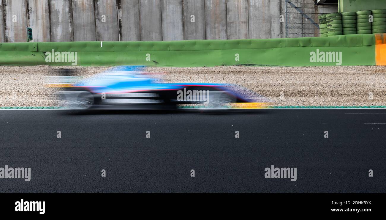 Speed concept blurred motion racing car on asphalt track side view Stock Photo