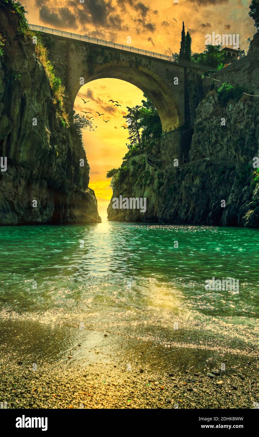 Fiordo di Furore, Amalfi coast picturesque golden hour sunset seascape scenic view on arched bridge between high rocks and stone beach. Italy Stock Photo
