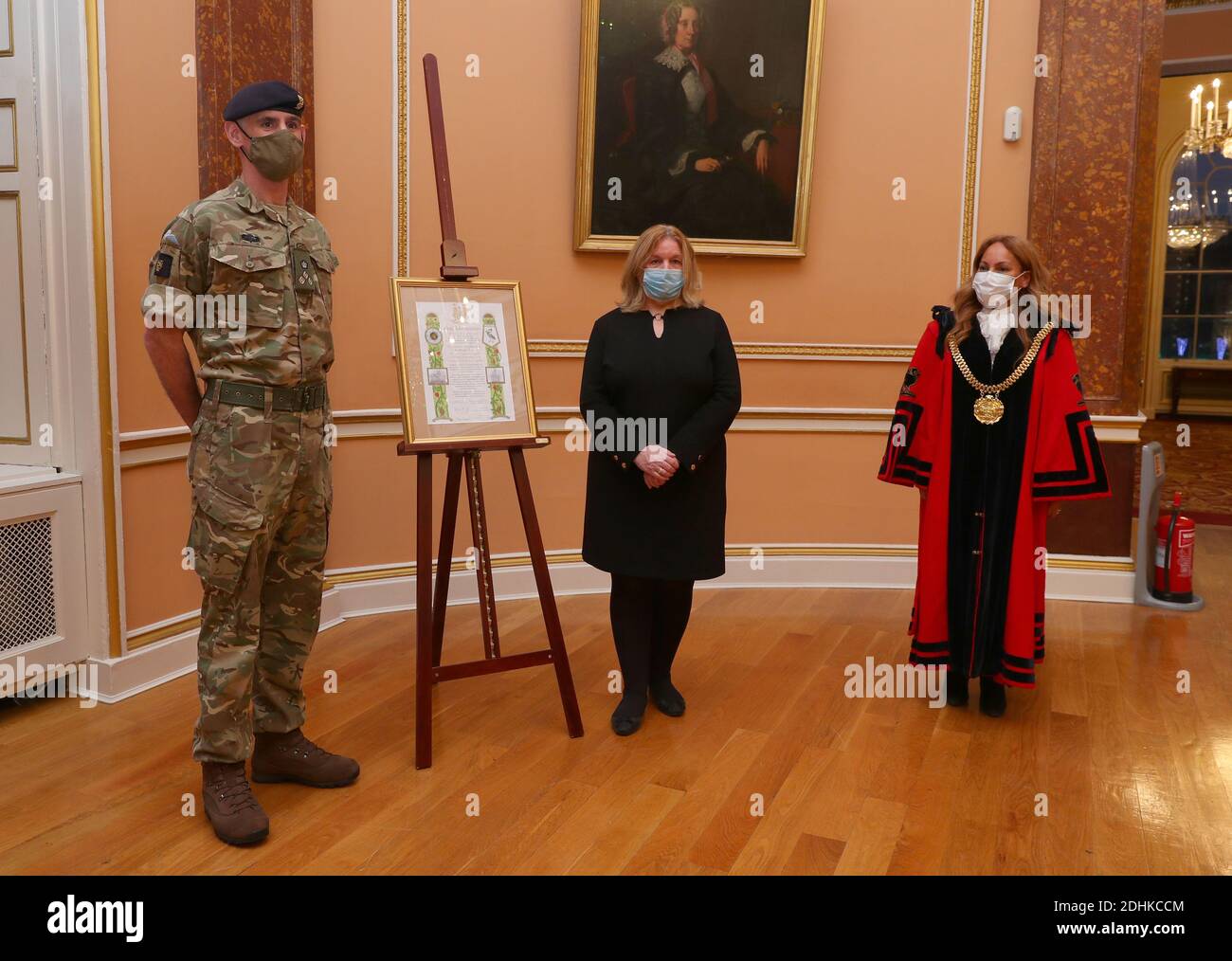 Lord Mayor of Liverpool, Anna Rothery and Deputy Mayor of Liverpool, Councillor Wendy Simon presents a scroll to Brigadier Joe Fossey, Commander of the 8th Engineer Brigade, in a ceremony at Liverpool Town Hall. The scroll proposes the inclusion in the Freedom Roll of Associations for the British Army regiments that supported the Covid testing pilot in Liverpool. The decision will be ratified at a council meeting in January and special commemorative coins will be issued to each of the troops involved in the operation as a civic gift from the city. Stock Photo