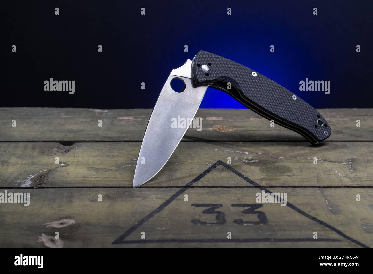 Knife with a black handle and a hole in the blade. The knife is in a