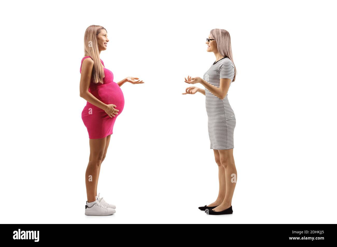 Full length profile shot of a pregnant woman having a conversation with another woman isolated on white background Stock Photo