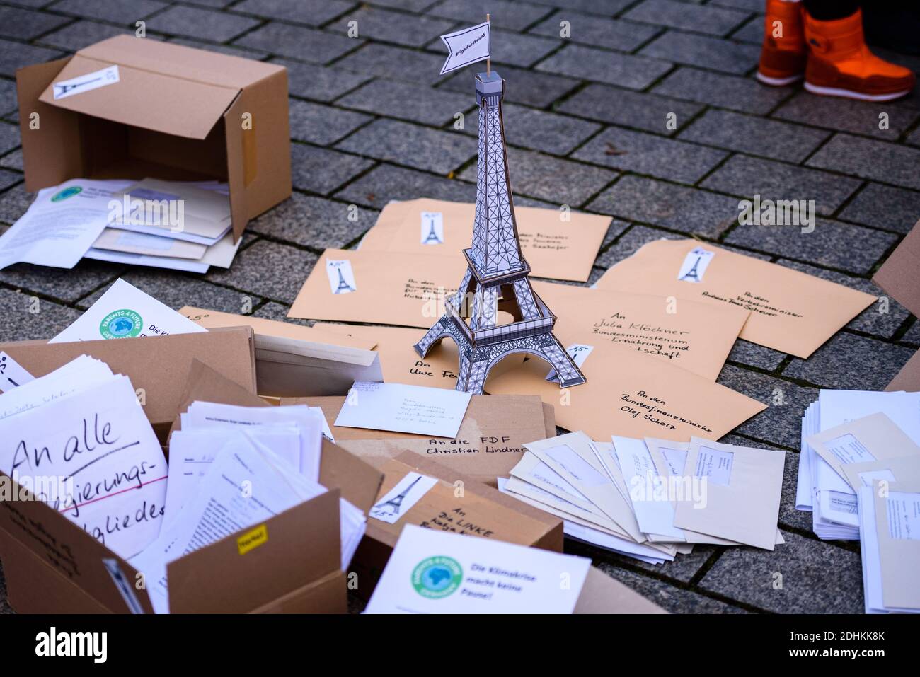 December 11, 2020, Berlin, Berlin, Germany: A paper model of the Eiffel Tower is seen next to a pile of documents and letters. With a  lettering reading ''#FightFor1Point5 - fight for 1.5 degrees!'' made of thousands of candles, the organizers around the climate movement Fridays for Future want to draw the attention of the German government to the compliance with this goal on the occasion of the fifth anniversary of the Paris Climate Agreement on December 12. In order to still reach the 1.5 degree target of the Paris climate agreement, a reduction of CO2 emissions by at least 60 percent is nec Stock Photo