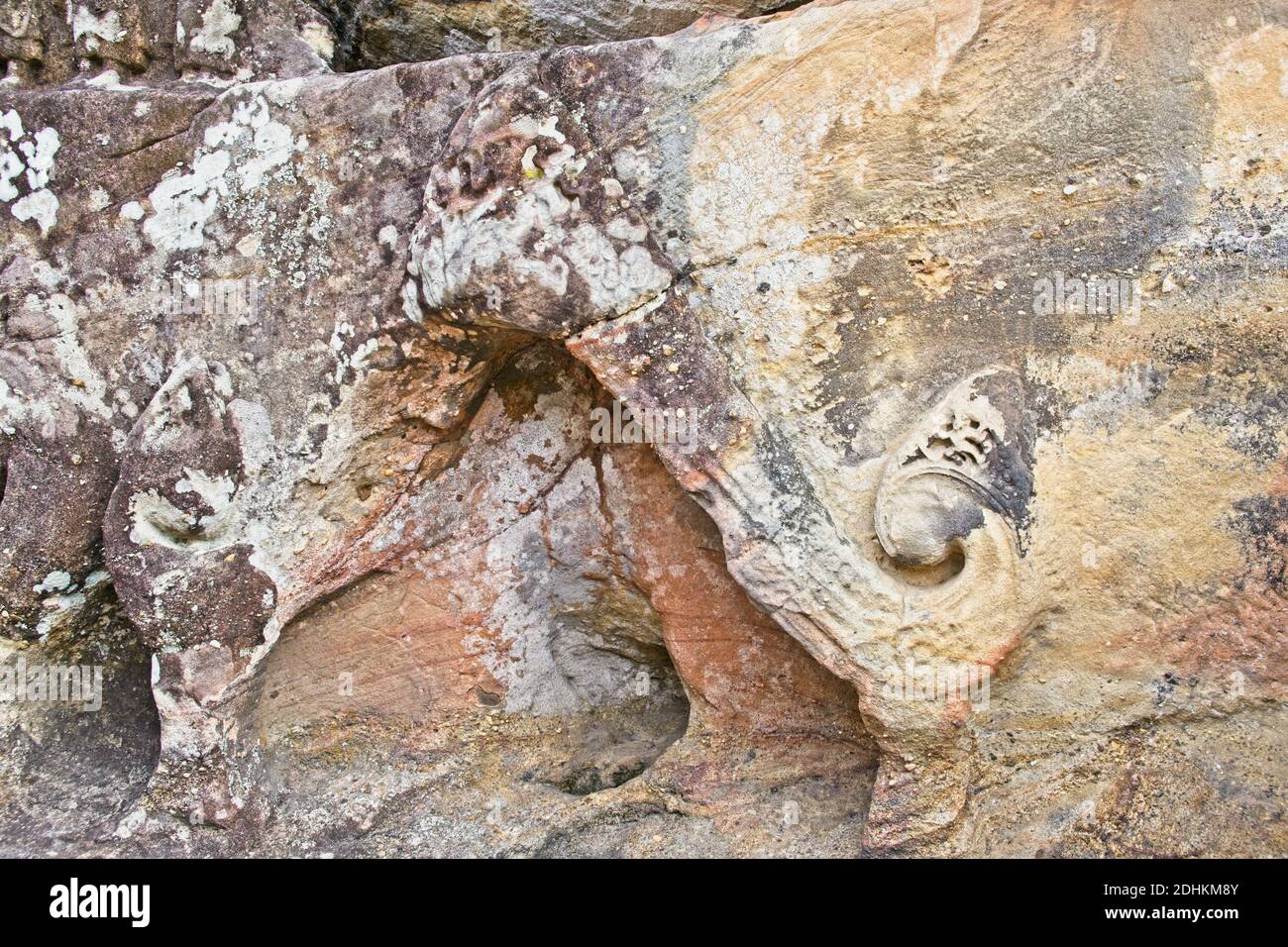 Hand carved images of Buddha and other decorations found in rock formations in secluded area within Buddha open temple. Stock Photo