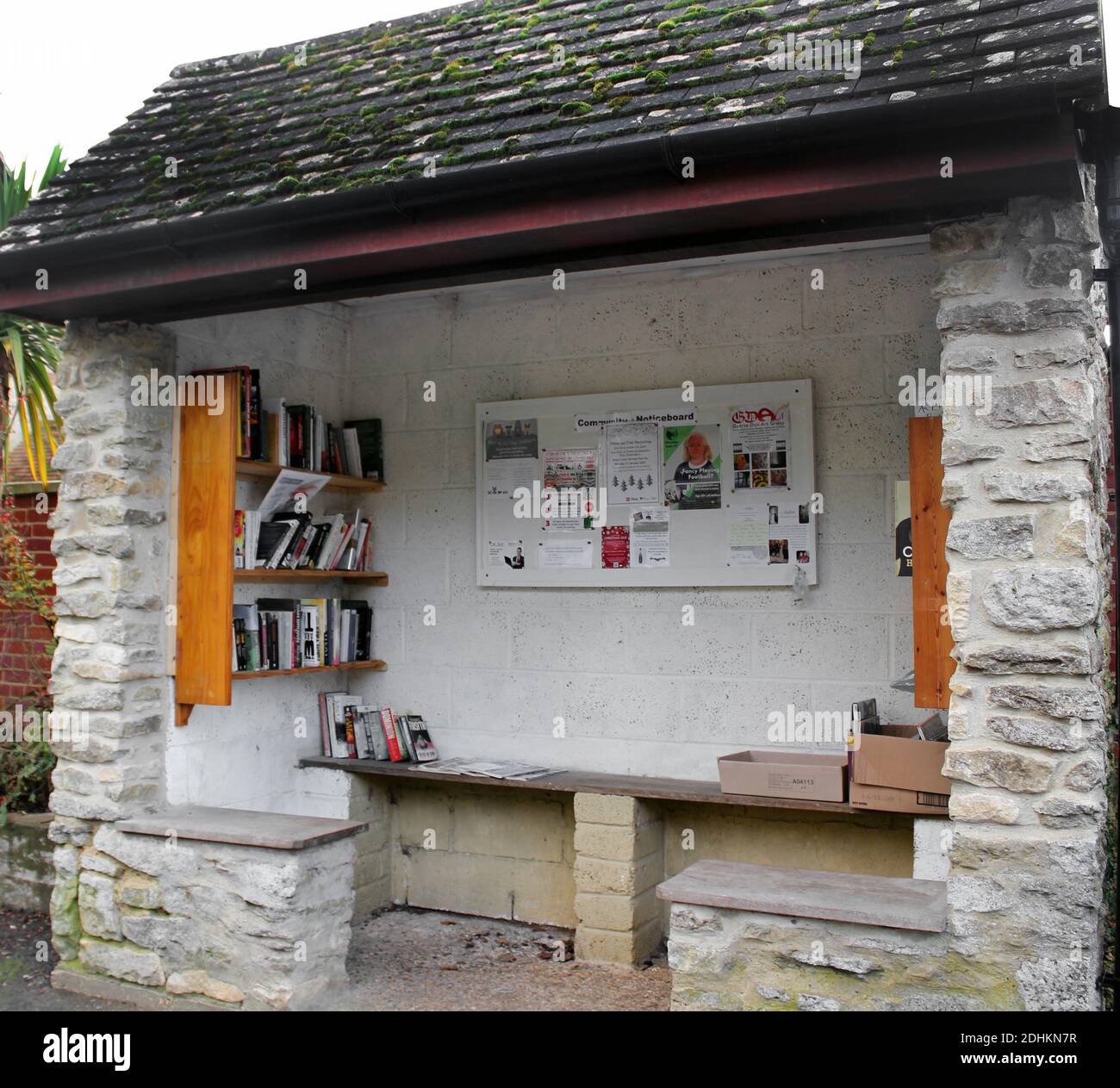 Garsington village Oxfordshire community noticeboard and donation library set up in the stone bus shelter at the top of The Hill and Oxford Road Stock Photo