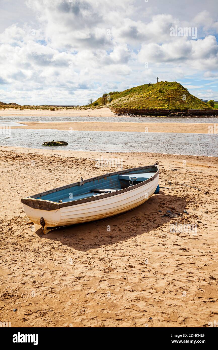 A small open fishing boat on the beach at low tide with Church Hill in the background, at Alnmouth, Northumberland, UK Stock Photo