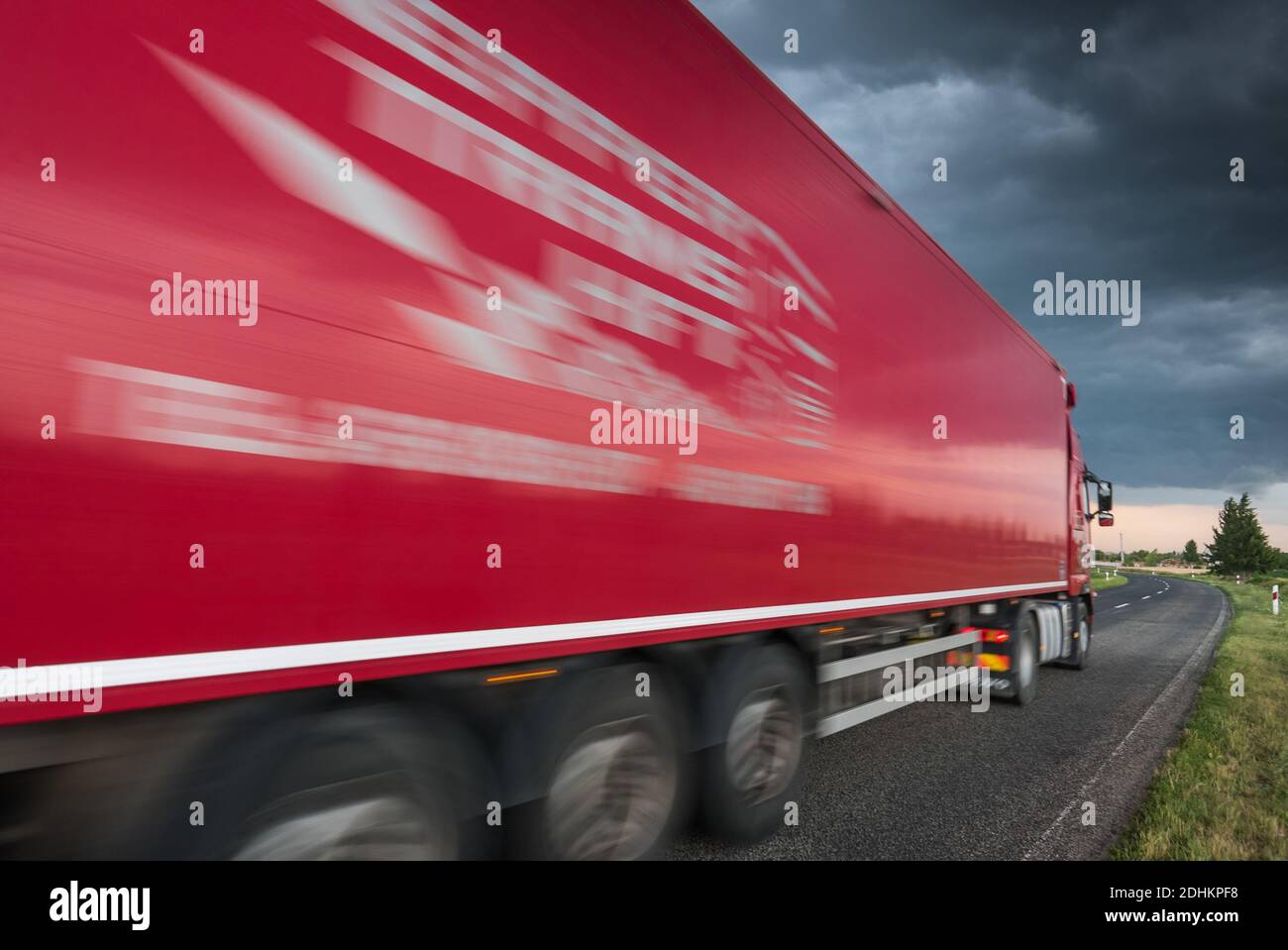 Red truck on asphalt road under stormy sky with clouds Stock Photo - Alamy