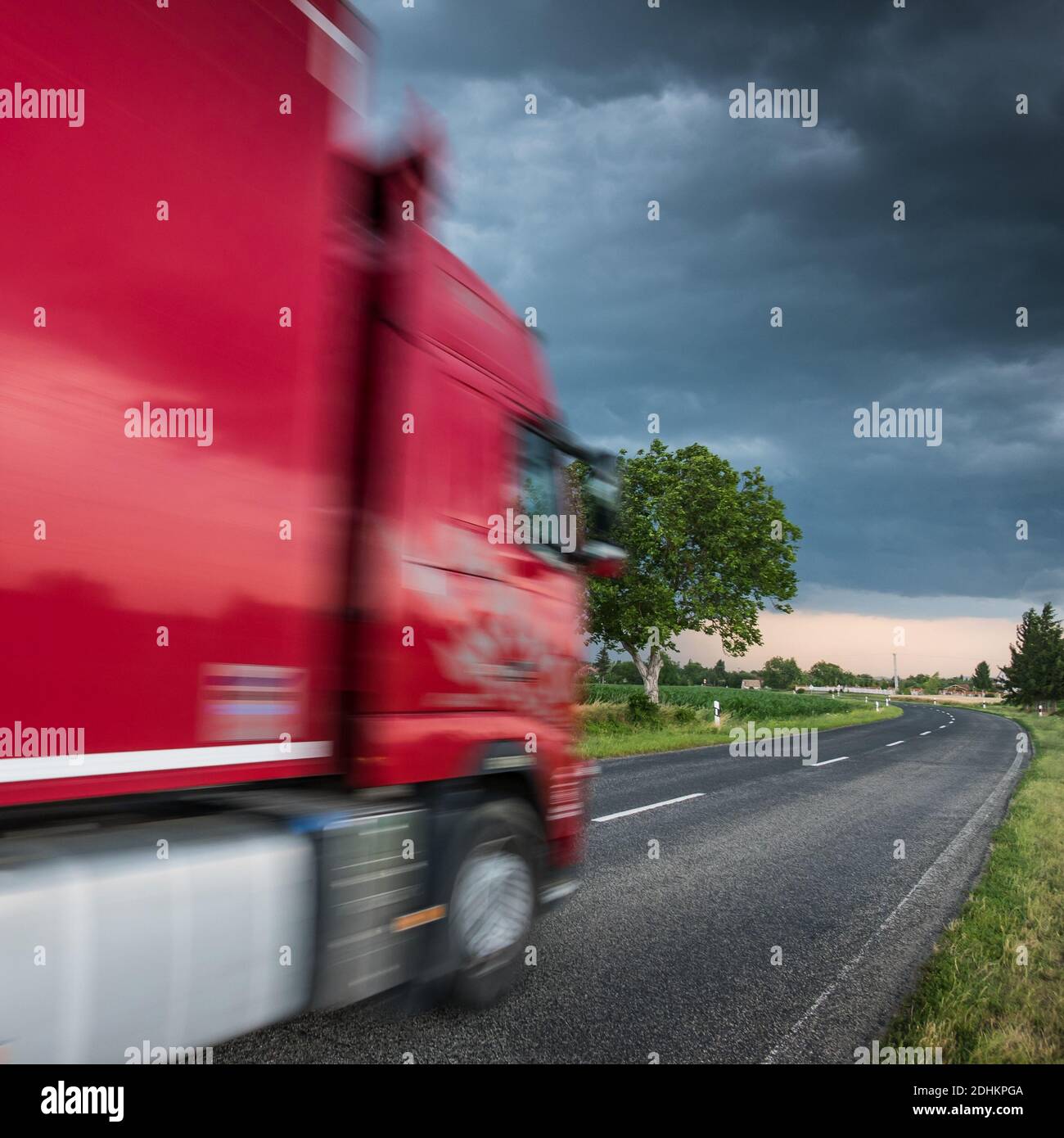 Red truck on asphalt road under stormy sky with clouds Stock Photo - Alamy