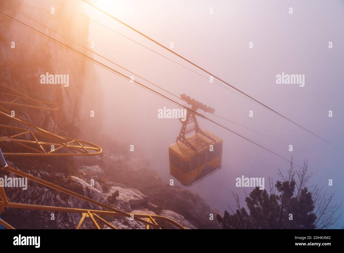The cable car in Crimea Ai-Petri mountains in thick fog. View from the cliff to the cable car with a rising funicular, mountains in the clouds Stock Photo
