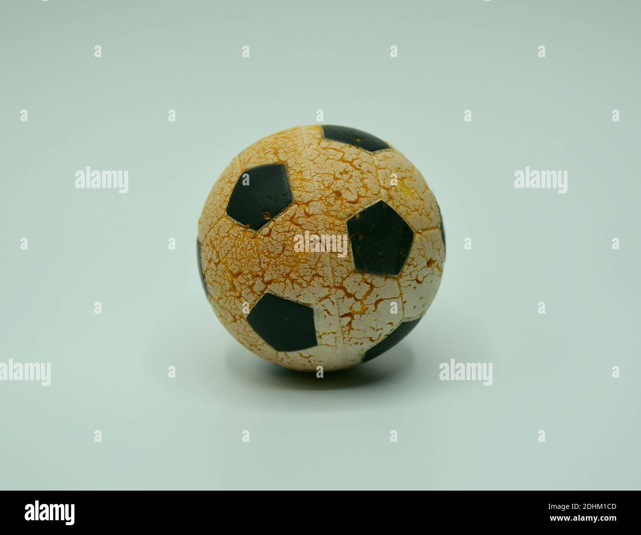 Small soccer ball worn by the sun in photo studio with white background