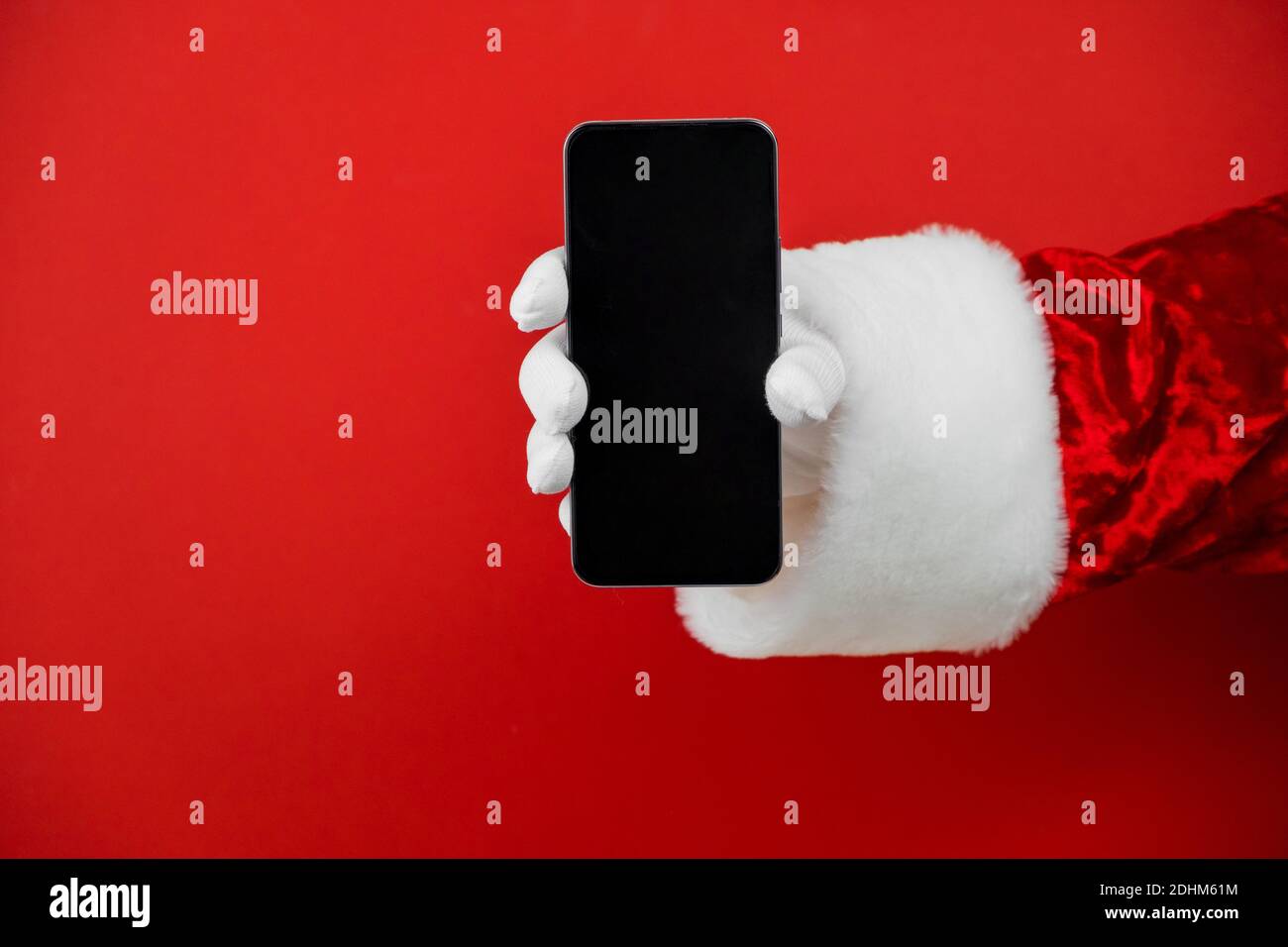 Santa Claus hand holding a smartphone with a blank screen. Mobile phone ...