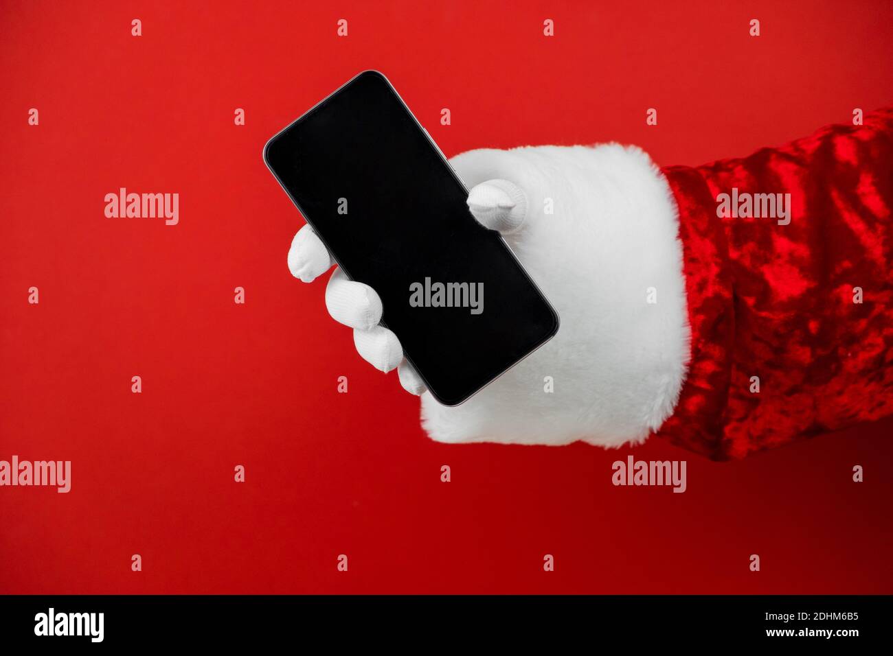 Santa Claus hand holding a smartphone with a blank screen. Mobile phone ...