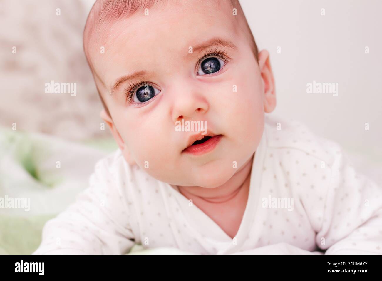 adorable baby boy with big eyes and long eyelashes. cute baby lying on