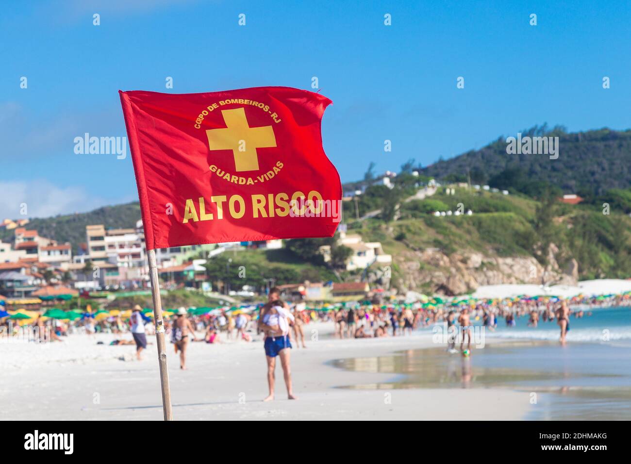 ARRAIAL DO CABO, RIO DE JANEIRO, BRAZIL - DECEMBER 26, 2019: Warning sign of a red flag at Praia Grande. At background People in the beach. Stock Photo