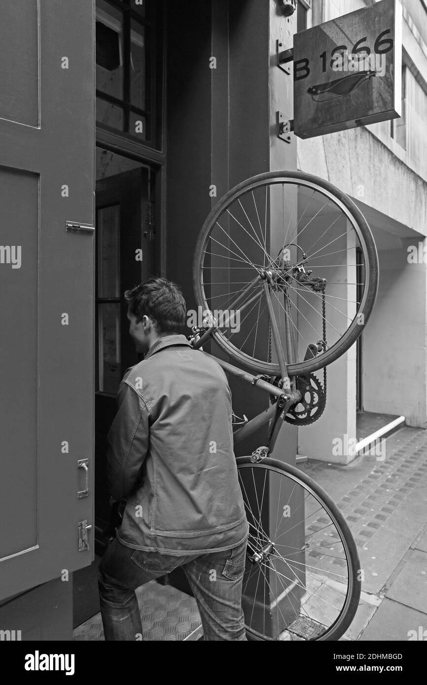 United Kingdom /London / Best of British/Brooks/B 1866 Brooks England store in Covent Garden,Male is bring bicycle inside the shop . Stock Photo