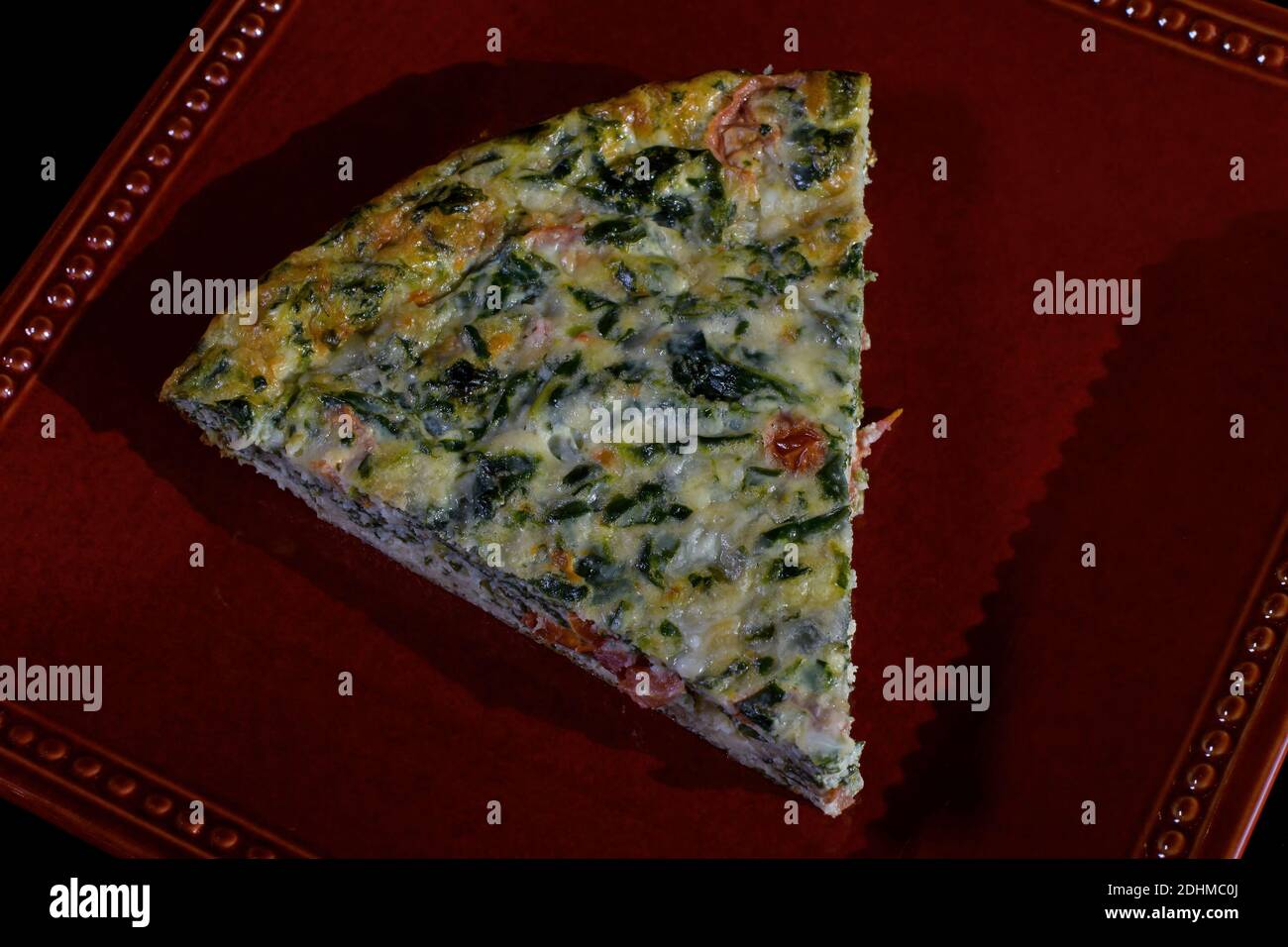Crustless quiche filled a with savory custard of milk, eggs, cheddar cheese, parmesan cheese, and mozzarella cheese. Stock Photo