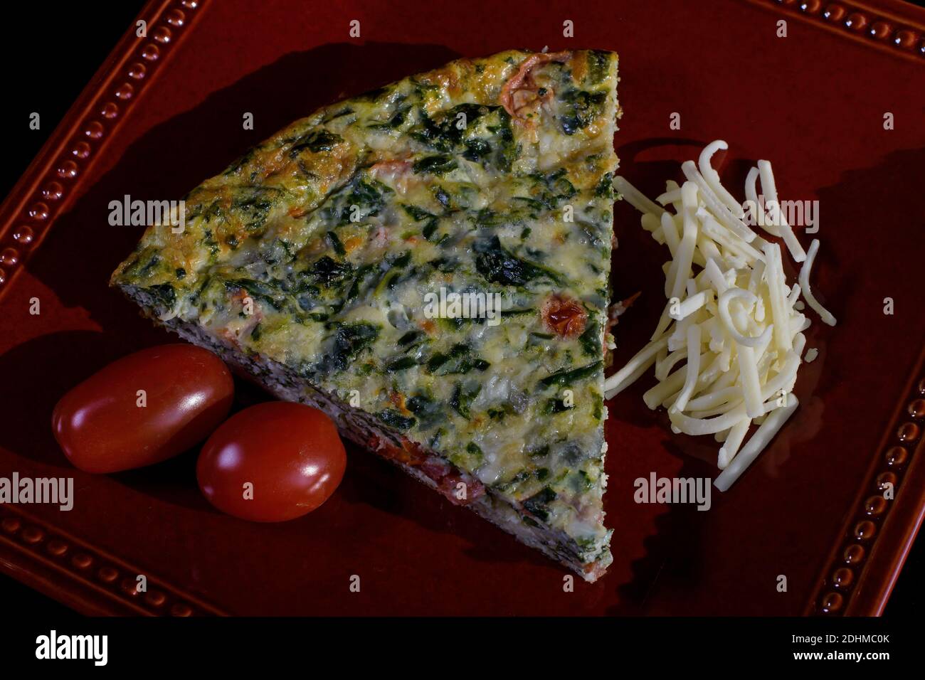 Crustless quiche filled a with savory custard of milk, eggs, cheddar cheese, parmesan cheese, and mozzarella cheese. Stock Photo