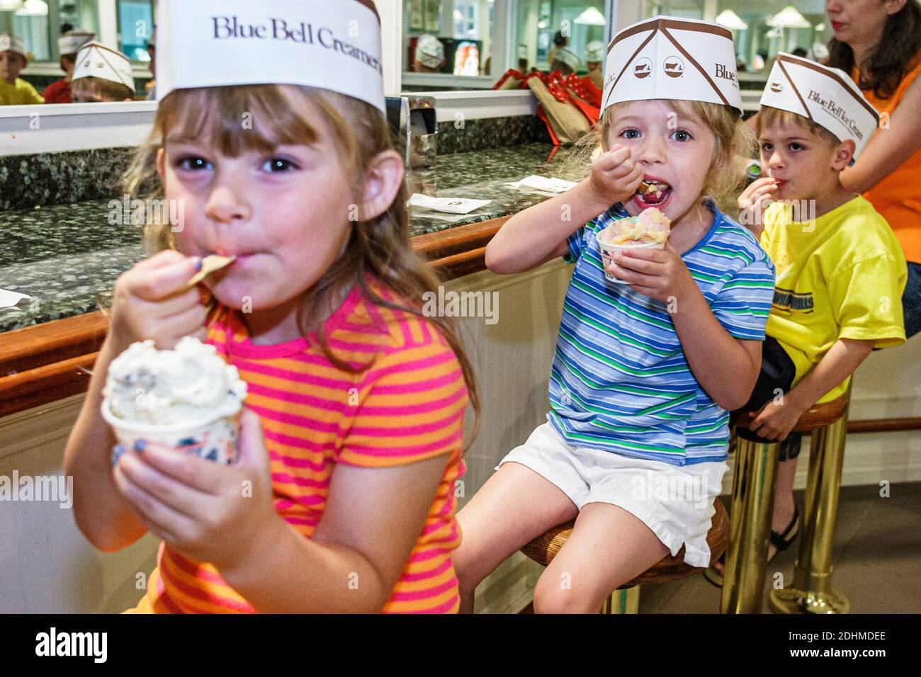 Alabama Sylacauga Blue Bell Creameries ice cream manufacturing plant production,children girls boy eating ice cream tour school field trip,students,we Stock Photo