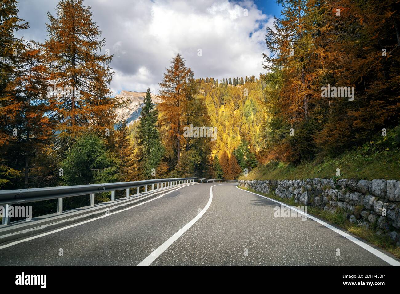 Beautiful mountain road with trees, forest and mountains in the backgrounds. Taken at state highway road of Dolomites mountain in Italy. Stock Photo