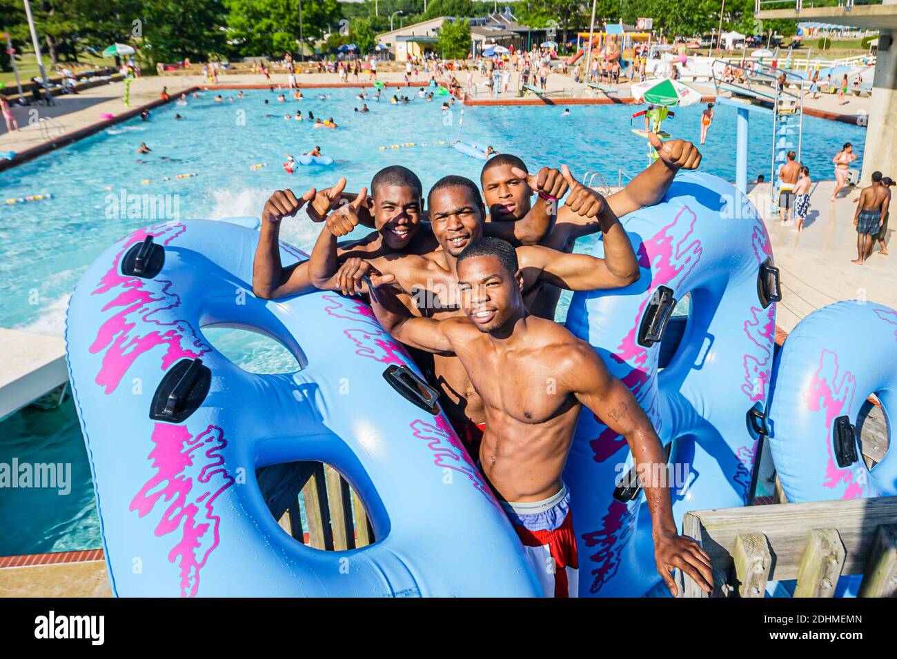 Alabama Decatur Point Mallard Park Waterpark,water slide swimming pool,Black teen teens teenage teenagers boys friends innertubes floats, Stock Photo