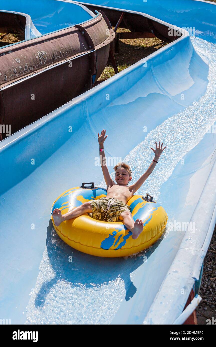 Alabama Decatur Point Mallard Park Waterpark,water slide boy riding inner tube down, Stock Photo