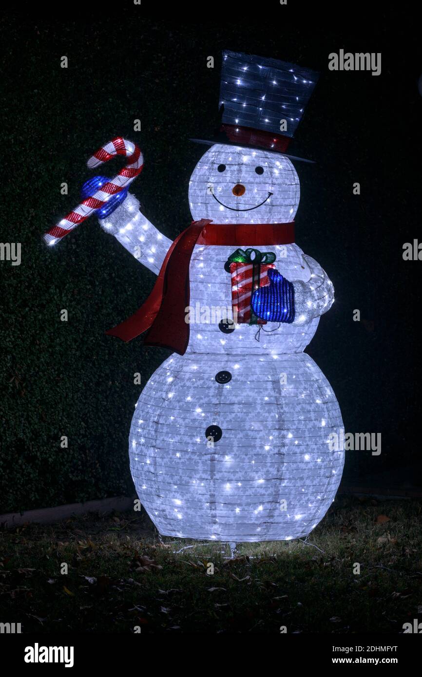Blow-up Snowman wearing hat and scarf and holding candy cane and gift Stock Photo