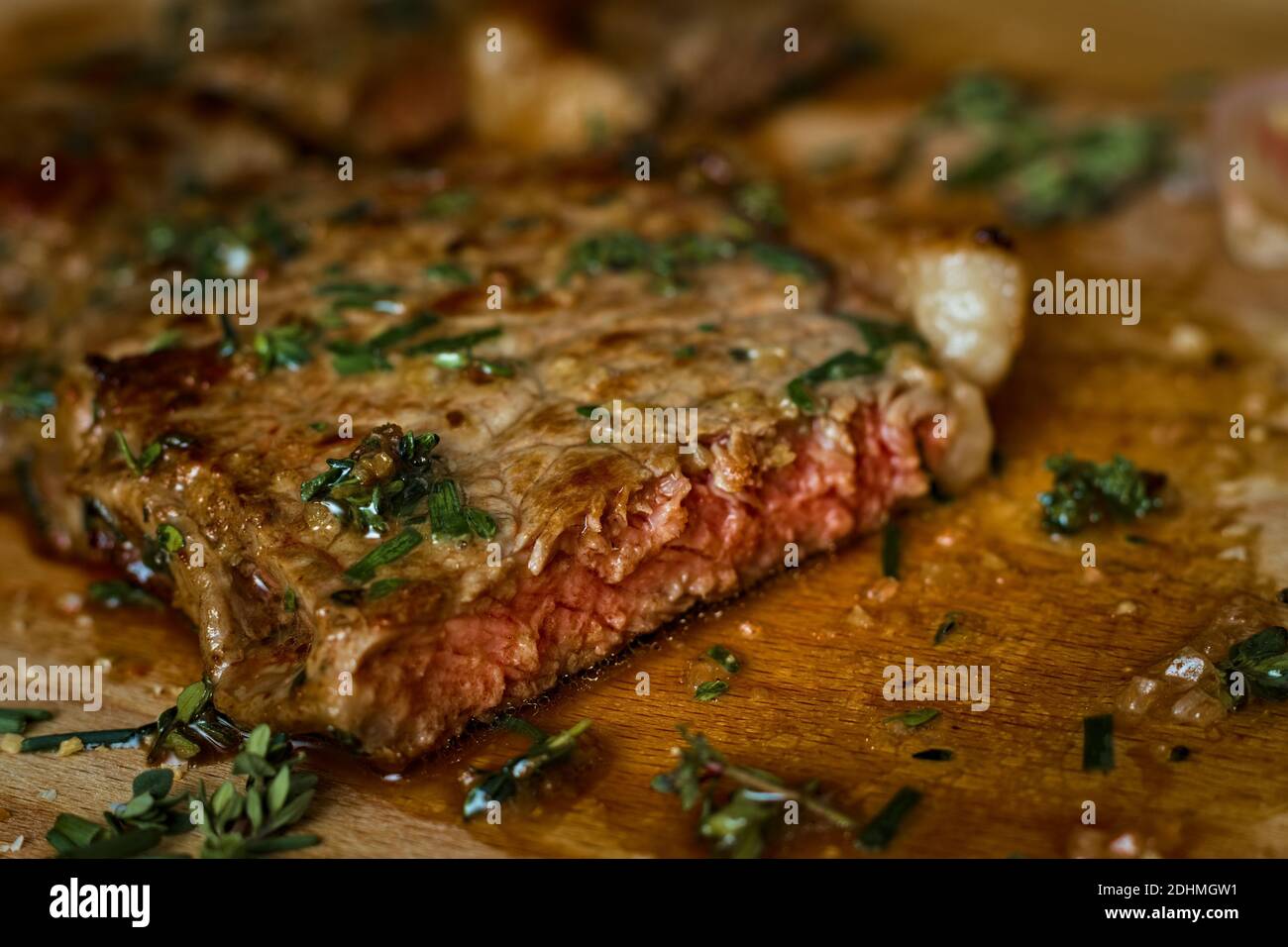Freshly seared medium rare sirloin steak on the chopping board Stock Photo