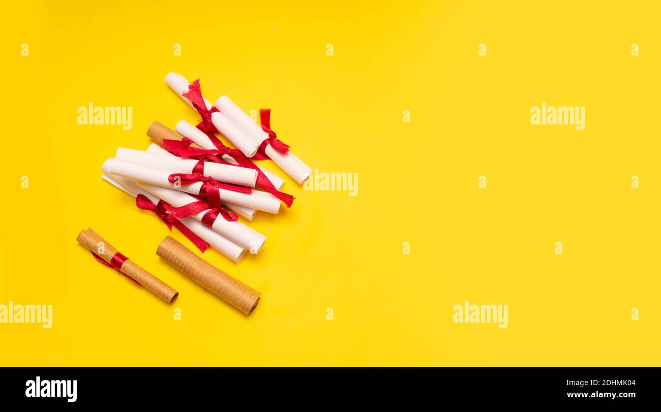 Small paper rolls with red strip on yellow background Stock Photo