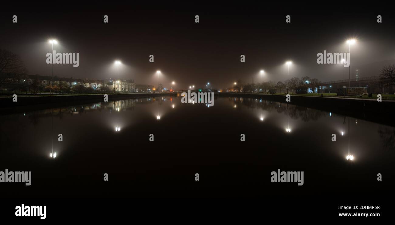 Streetlights are diffused by mist rising from Cumberland Basin on an autumn night on Bristol's Floating Harbour. Stock Photo