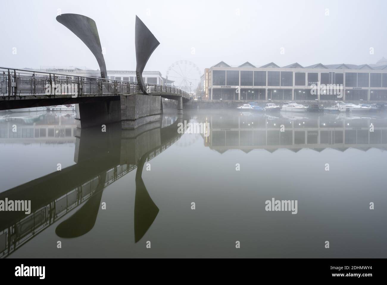 Mist hangs over the redeveloped Harbourside warehouses at Pero's Bridge on Bristol's Floating Harbour. Stock Photo