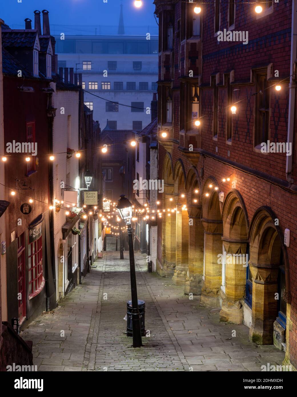Lights illuminate the picturesque old street of shops at Christmas Steps on  a misty winter morning in Bristol Stock Photo - Alamy