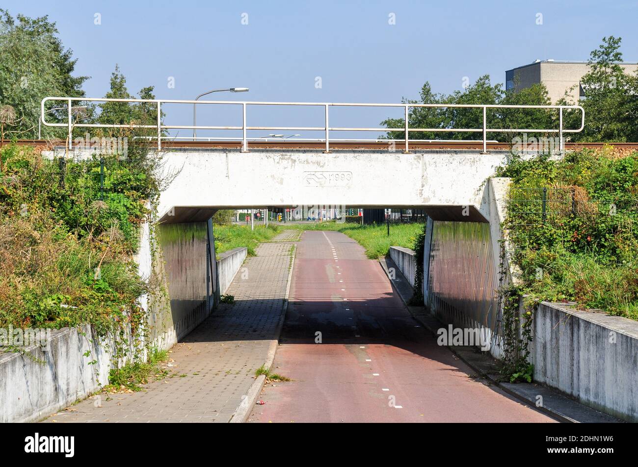 A cycle path dips below the Tilburg–Nijmegen railway in a concrete underpass in the industrial Kirkenbos neighbourhood of Nijmegen. Stock Photo