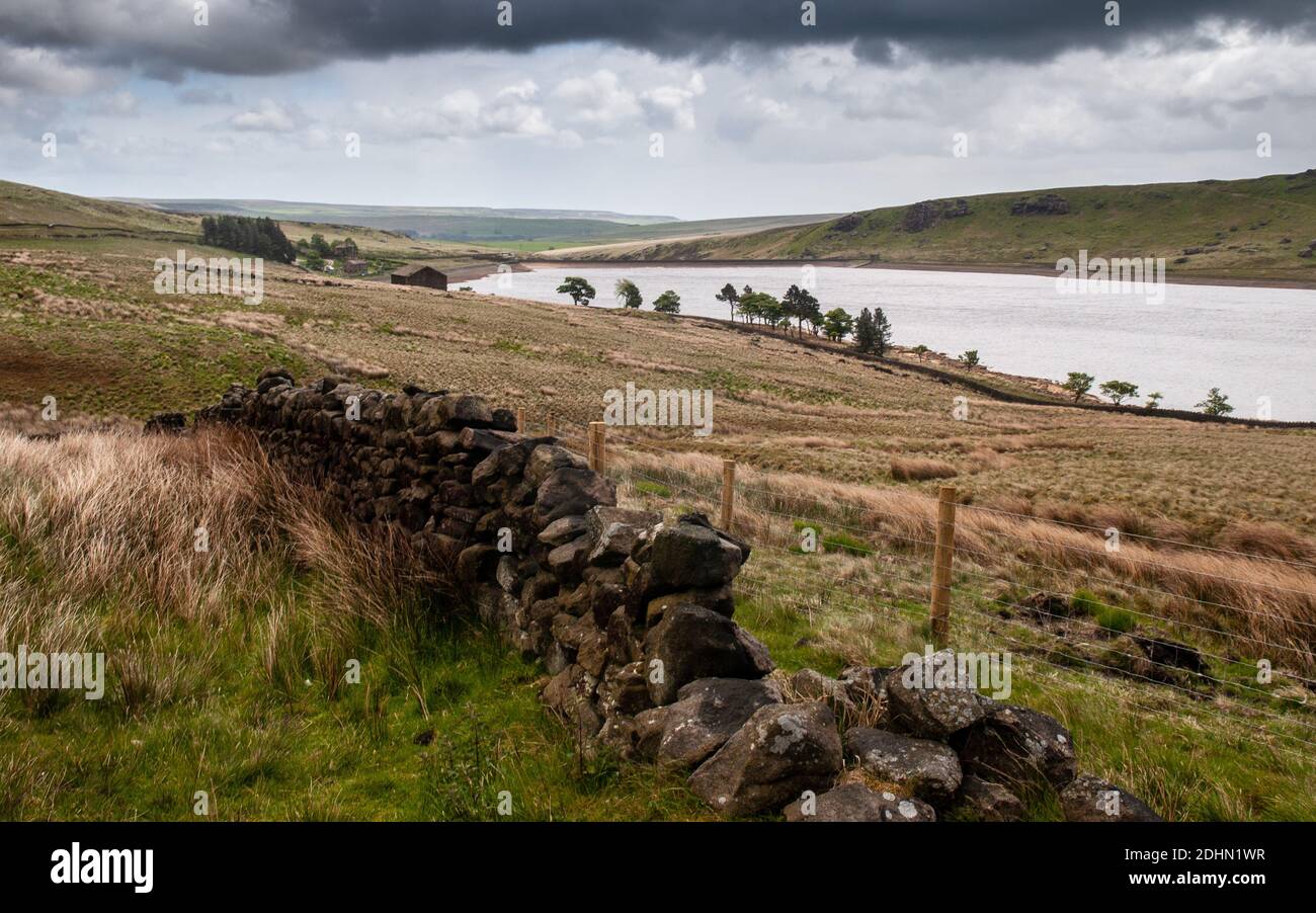 Low water levels reveal rocky shores of Widdop Reservoir high on the moors of the South Pennines hills above Calderdale in West Yorkshire. Stock Photo