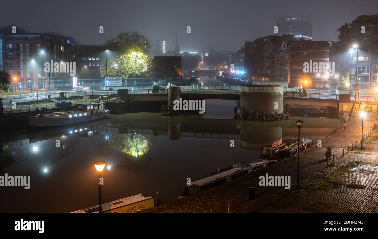 Redcliffe Bridge and the converted warehouse apartment buildings of Redcliffe Quay and Welsh Back are shrouded in mist on a winter night on Bristol's Stock Photo