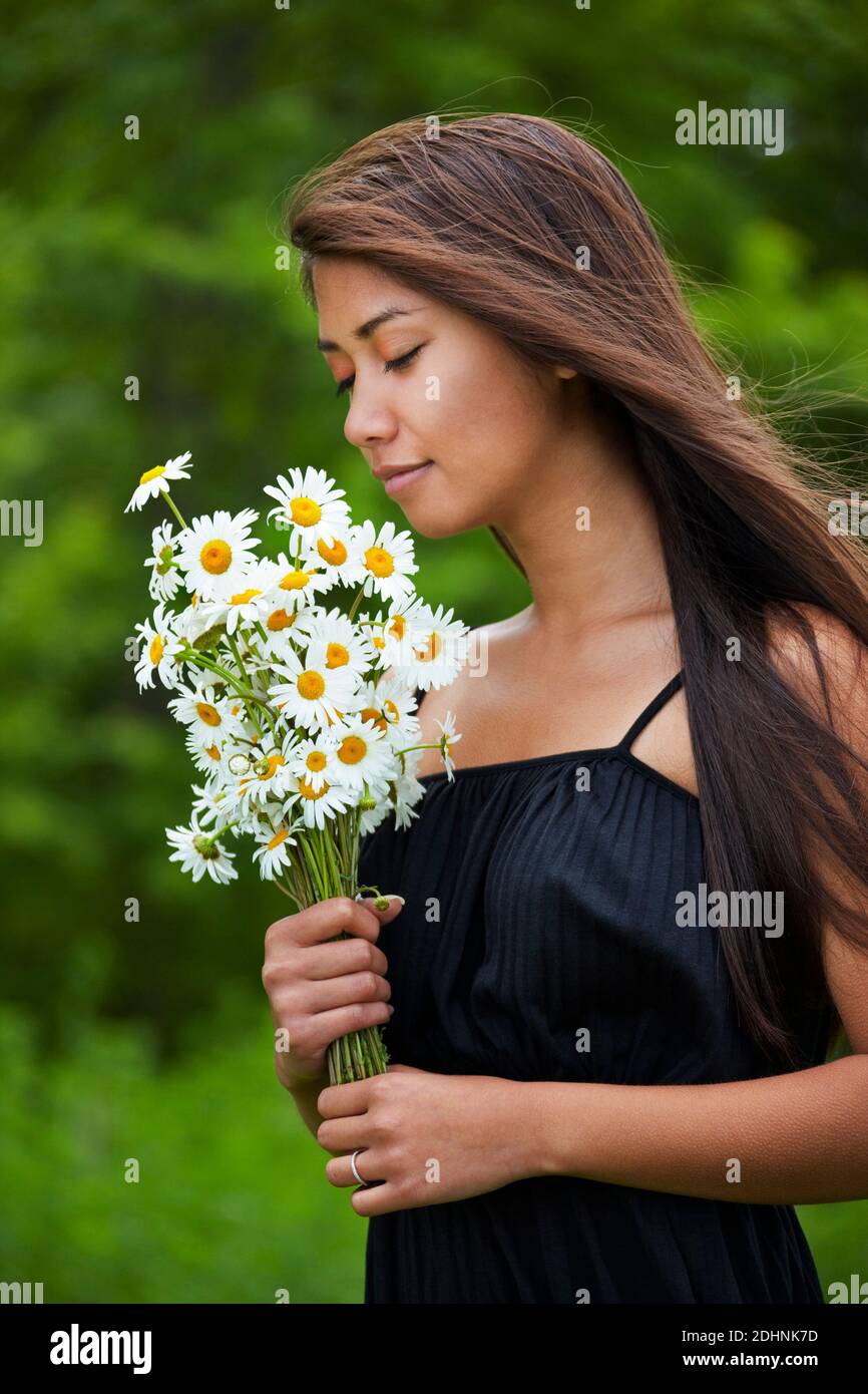 Woman Smelling a Bouquet of Daisies Stock Photo