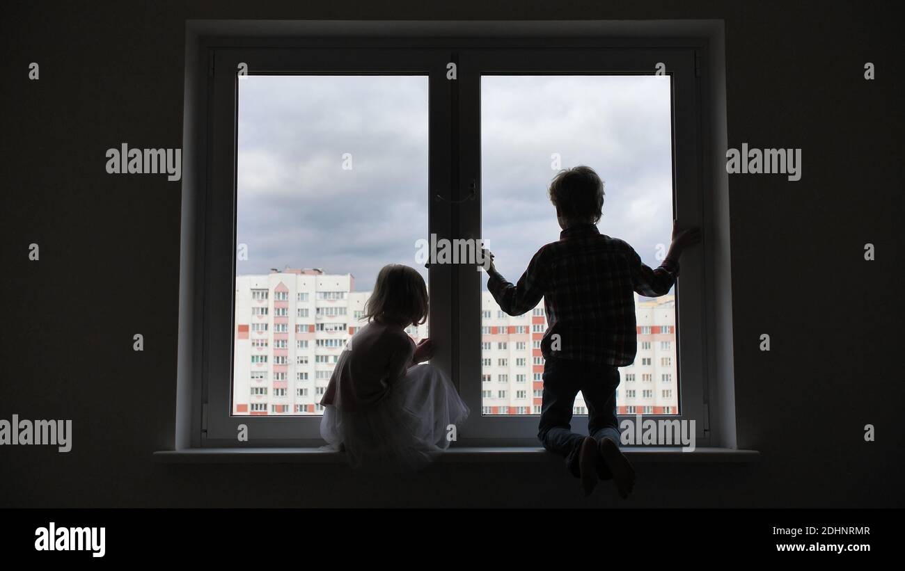 Silhouette of children on the background of a window in the apartment ...