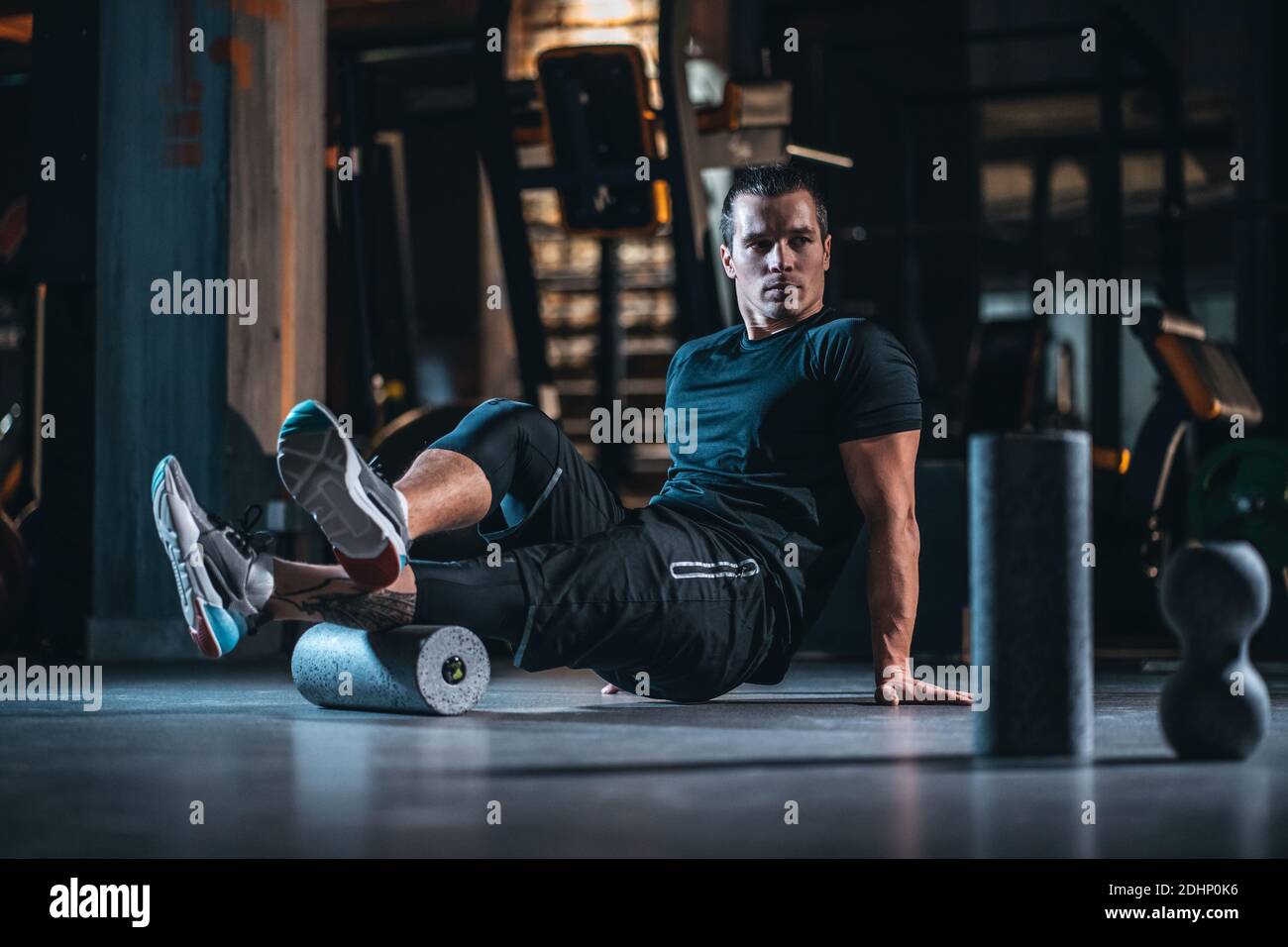 young man has crossfit workout with roller and weight in gym Stock Photo -  Alamy