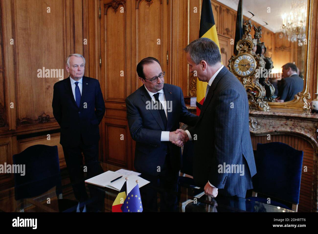 France's President Francois Hollande (C) shakes hands with Belgium's Ambassador to France Vincent Mertens de Wilmars as French Minister of Foreign Affairs and International Development Jean-Marc Ayrault looks on after paying homage to the victims of the Brussels terror attacks, at the Belgium embassy in Paris, France on Tuesday, March 22, 2016. Bombs exploded at the Brussels airport and one of the city's metro stations earlier today, killing at least 34 and injuring dozens of people. The Islamic State group claimed responsibility for the attacks. Photo by Thibault Camus/Pool/ABACAPRESS.COM Stock Photo