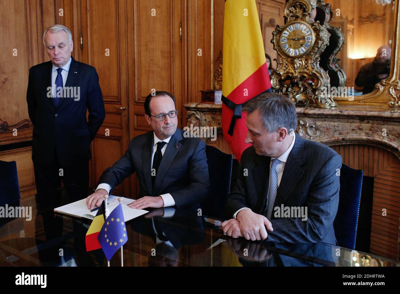 France's President Francois Hollande (C) signs the condolence book as Belgium's Ambassador to France Vincent Mertens de Wilmars (R) and French Minister of Foreign Affairs and International Development Jean-Marc Ayrault look on after paying homage to the victims of the Brussels terror attacks, at the Belgium embassy in Paris, France on Tuesday, March 22, 2016. Bombs exploded at the Brussels airport and one of the city's metro stations earlier today, killing at least 34 and injuring dozens of people. The Islamic State group claimed responsibility for the attacks. Photo by Thibault Camus/Pool/ABA Stock Photo