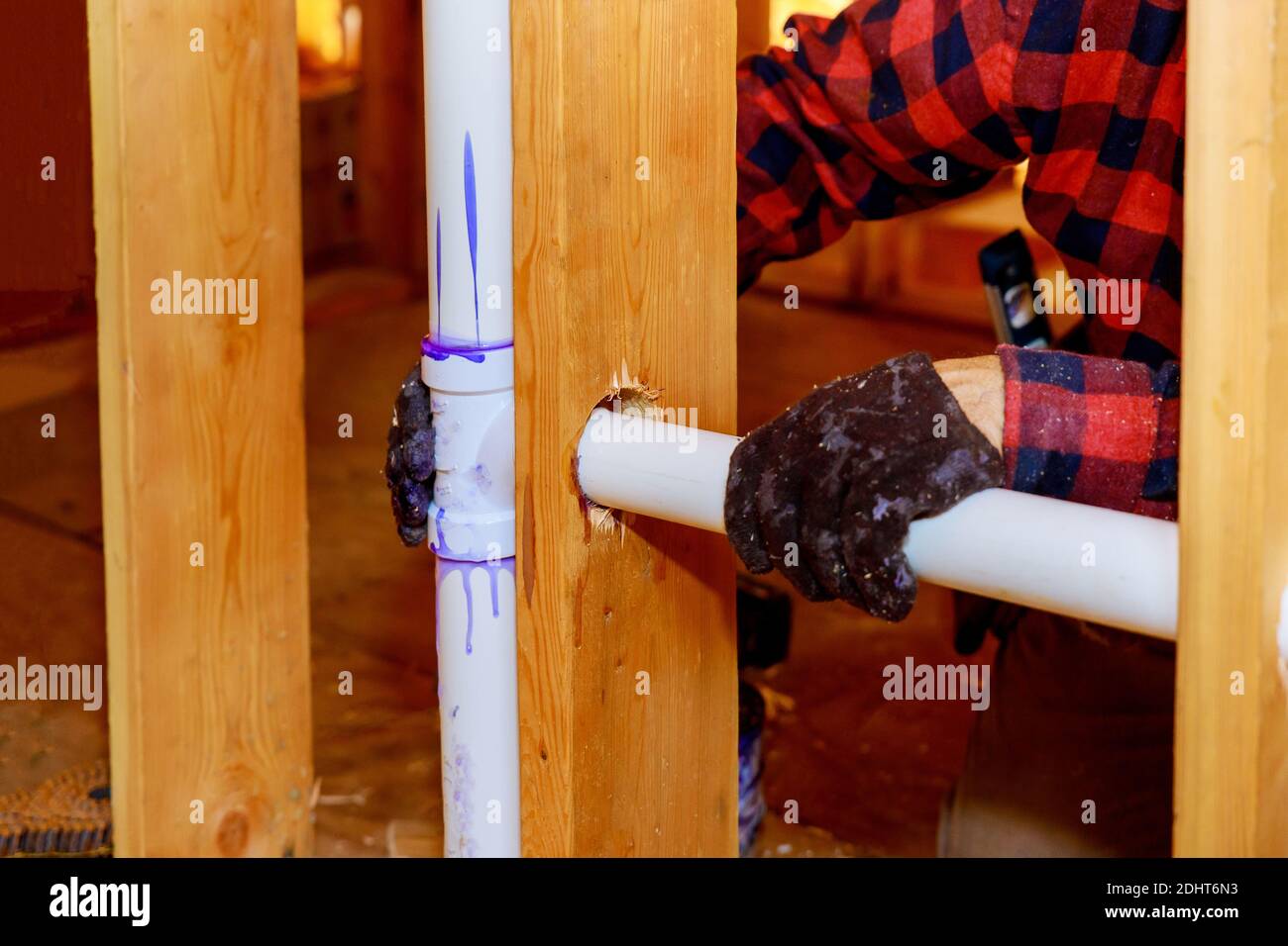 Mount under construction a plumber glue white PVC pipe, on new plastic